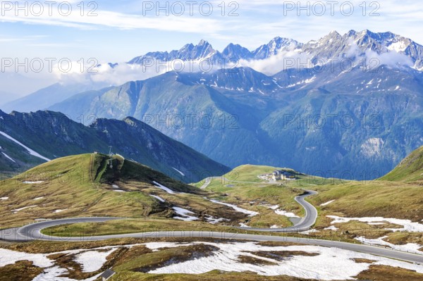View to the south from Hochtor pass summit of Grossglockner High Alpine Road to high plateau with serpentines of winding Alpine road mountain road pass road Alpine pass behind mountain range Grossglockner Group, Carinthia, Austria