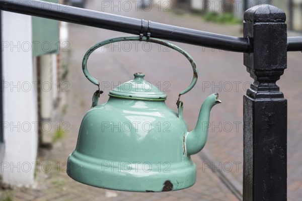 Old enamel tea or water kettle, decoration in front of a tea shop, province of Groningen, Netherlands