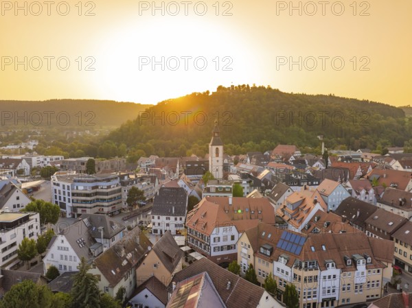 Charming old town at sunset with church tower and surrounding hills, small town pearl Nagold, Black Forest, Germany