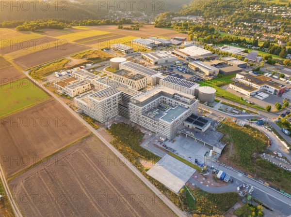 Industrial complex in a rural setting at sunset with neighbouring fields, new hospital building, Calw health campus, Black Forest, Germany