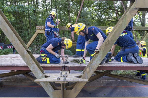 Construction of a temporary bridge over a slipped road crossing a stream, by the bridge construction section of the THW, 18 metre long steel bridge of the Krupp-D type, is assembled in around 8 hours, large-scale exercise FÜLEX25 lasting several days, of the THW North Rhine-Westphalia regional association, over 3500 volunteers from the 127 North Rhine-Westphalia local associations practise on 4 weekends, many different deployment scenarios