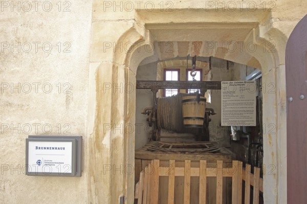 Well house with winch and water bucket, water bucket, rope, winch, pulley, pulley block, pulley, hook, interior view, record, deepest well shaft, text, inscription, information board, castle, Veste Heldburg, Heldburg, Thuringia, Germany