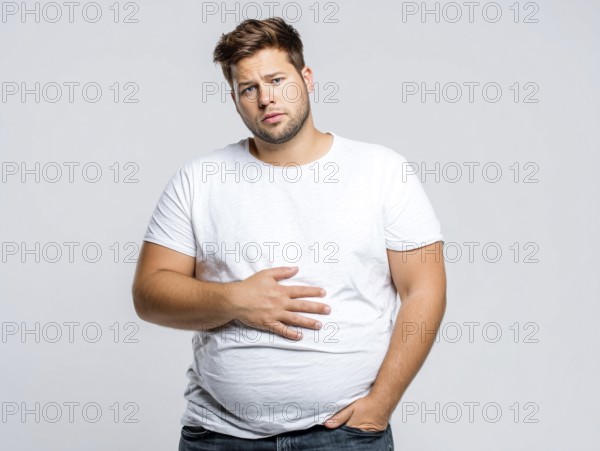 Overweight young man looks worried and holds his hand on his stomach, AI generated, AI generated