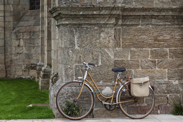 Women's bicycle leaning against a church façade, Guingamp, Brittany, France
