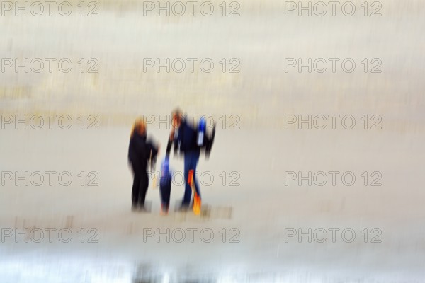 Couple with child on the North Sea beach, wipe effect, long exposure, Sankt Peter-Ording, Eiderstedt peninsula, Wadden Sea National Park, North Frisia, Schleswig-Holstein, Germany