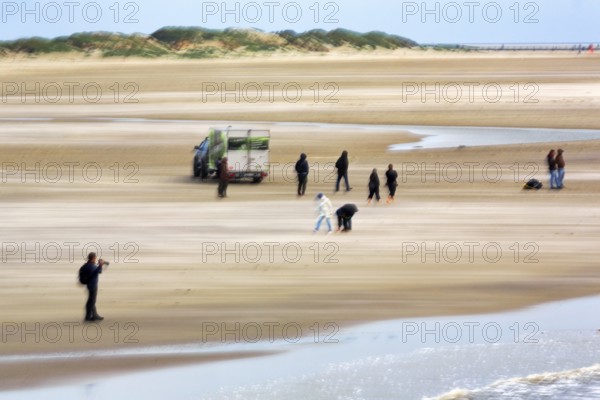 Photographer, walker on the North Sea beach, car, dunes on the horizon, wiping effect, long exposure, Sankt Peter-Ording, Eiderstedt peninsula, Wadden Sea National Park, North Frisia, Schleswig-Holstein, Germany