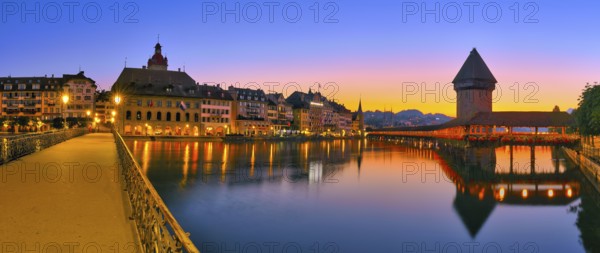 Chapel bridge with water tower reflected in the river Reuss, panorama of Lucerne's old town at dawn, Canton of Lucerne, Switzerland