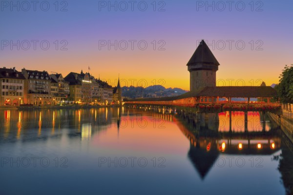 Chapel bridge with water tower reflected in the river Reuss, Lucerne old town at dawn, Canton Lucerne, Switzerland