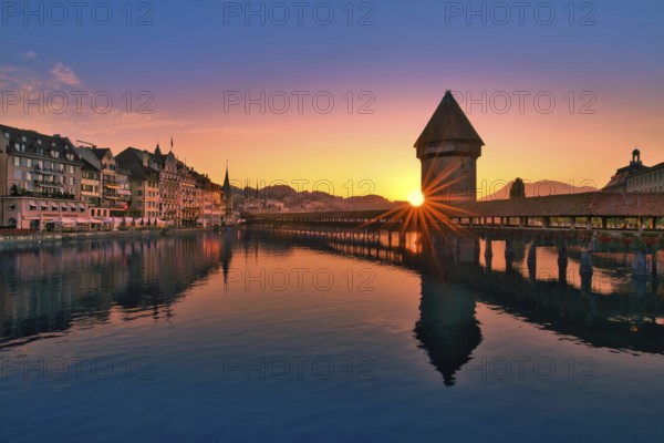 Chapel bridge with water tower reflected in the river Reuss at sunrise, view of Lucerne old town, Canton Lucerne, Switzerland