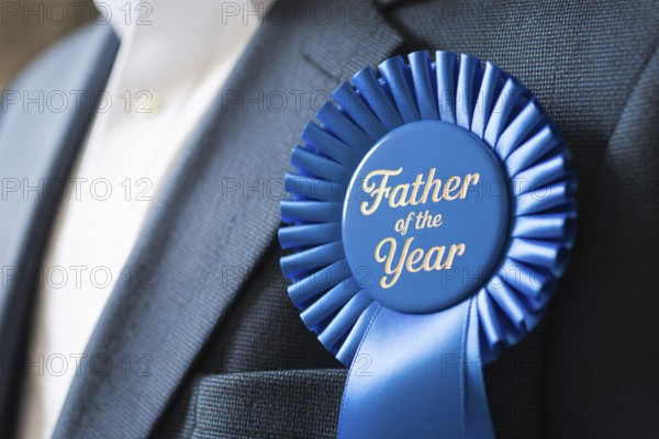 Close up of Father of the Year award ribbon pinned to man's suit chest. Celebration of fatherhood and recognition. Generative AI, AI generated