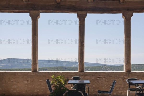A terrace with mountain views, mountain village Simiane la Rotonde, Département Alpes-de-Haute-Provence, Region Provence-Alpes-Côte d'Azur, France
