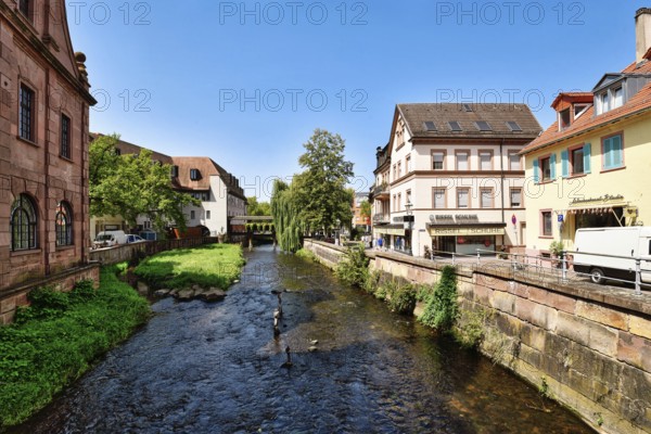 Ettlingen, Germany - August 13th 2025: Alb brook in historic center of Ettlingen, Germany. Small creek with old buildings on sunny day