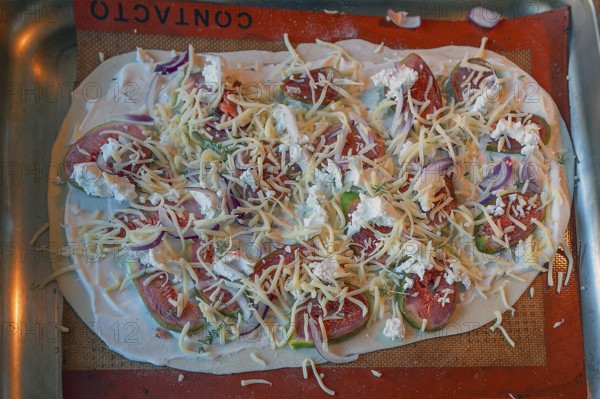 Tarte flambée with figs, onions and two types of cheese on a baking tray in the oven, Baden-Württemberg, Germany