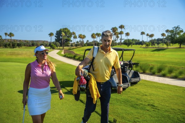 Golfers are walking on a beautiful golf course, carrying golf clubs and enjoying a sunny day of leisure and sport