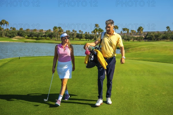 Golfers are walking on a beautiful golf course on a sunny day, enjoying their game and the outdoors