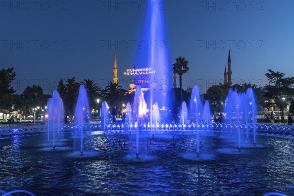 Majestic mosque providing a backdrop to illuminated fountains, creating a captivating scene in istanbul at twilight