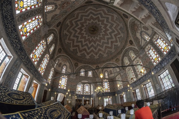 Wide angle view of the ornate ceiling and stained glass windows inside suleymaniye mosque, a historical landmark in istanbul, turkey