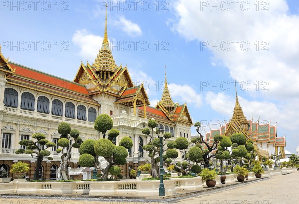 Ornate buildings with golden roofs and decorative elements stand amidst manicured gardens, representing thailand's rich cultural heritage