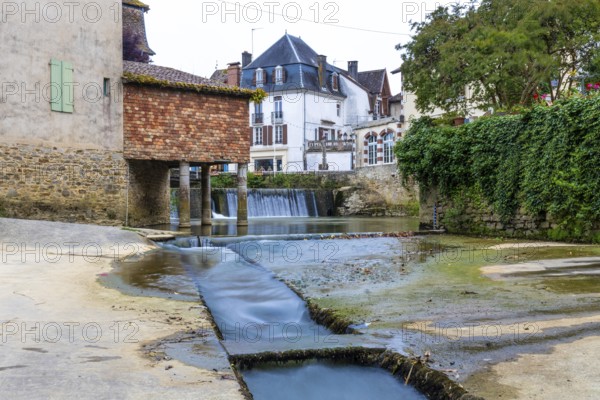 The salt museum, a captivating landmark in salies de bearn, france, showcasing its rich salt history alongside a picturesque waterfall