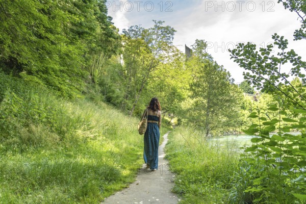 Tourist enjoying summer holidays walking along gave d'oloron river in sauveterre de bearn, a charming medieval village in the pyrenees atlantiques, france