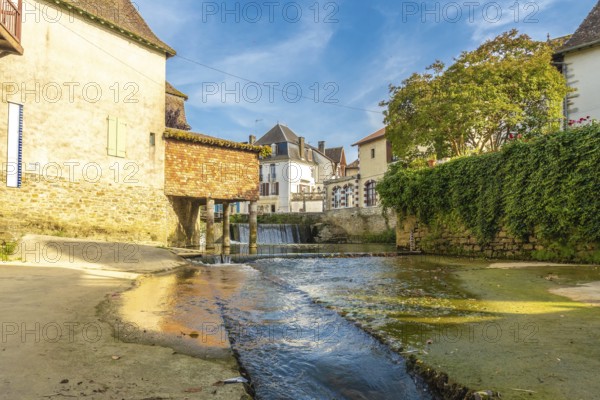 Scenic view of a small waterfall flowing through the charming village of salies de bearn in the pyrenees atlantiques region of france