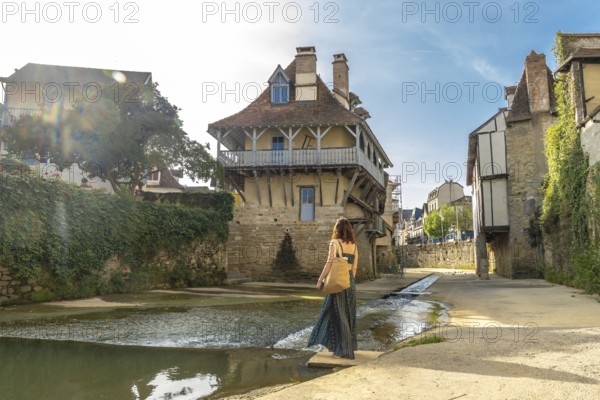 Tourist enjoying the picturesque architecture and the saleys river flowing through the charming village of salies de bearn, a popular destination in the pyrenees atlantiques region of france