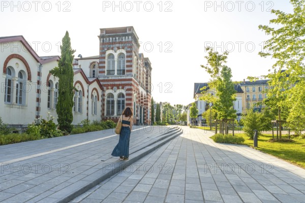 Woman strolling through salies de bearn, enjoying the charming architecture and tranquil atmosphere of this french village
