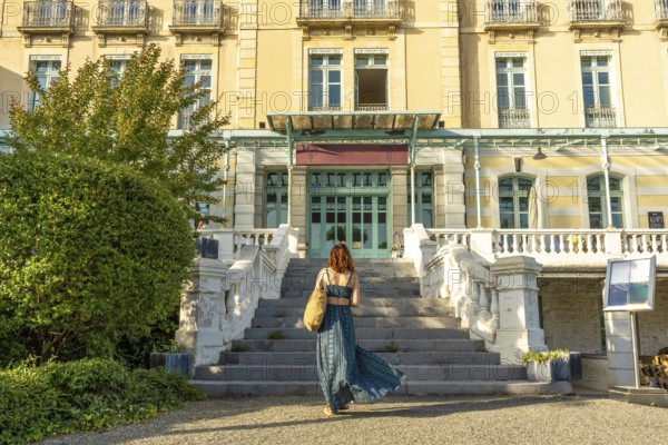 Tourist ascending stairs to a grand hotel in salies de bearn, france, enjoying a summer vacation