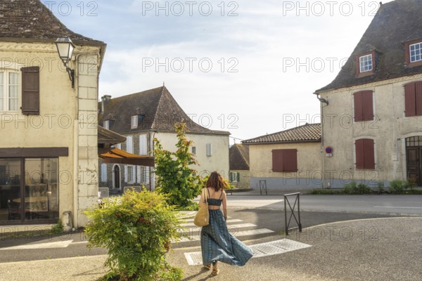 Tourist exploring charming streets of salies de bearn in france, enjoying summer vacation in a traditional european village