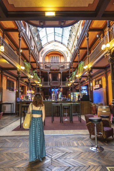 Tourist admiring the belle epoque architecture of the casino of salies de bearn, with its wooden galleries and glass roof