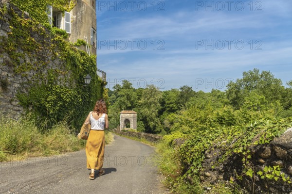 Tourist walking on a sunny day in sauveterre de bearn, france, exploring the medieval architecture and enjoying summer vacation