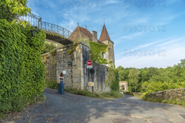 Tourist walking in the beautiful medieval village of sauveterre de bearn, in the pyrenees atlantiques department, in the nouvelle aquitaine region of southwestern france