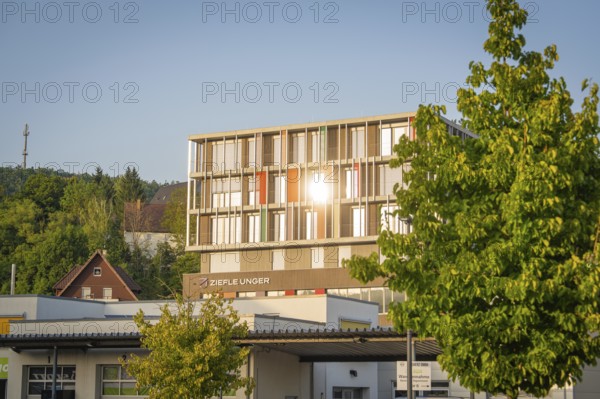 Modern office building with sunshine and trees in an urban area, Nagold, district of Calw, Black Forest, Germany
