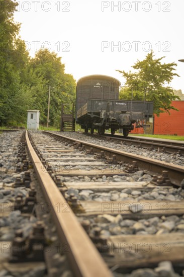 Railway tracks in the foreground leading to a historic train carriage, Nagold, district of Calw, Black Forest, Germany