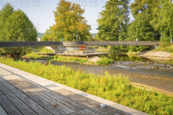 River landscape with bridge, surrounded by green trees and a wooden footbridge along the path, Nagold, district of Calw, Black Forest, Germany