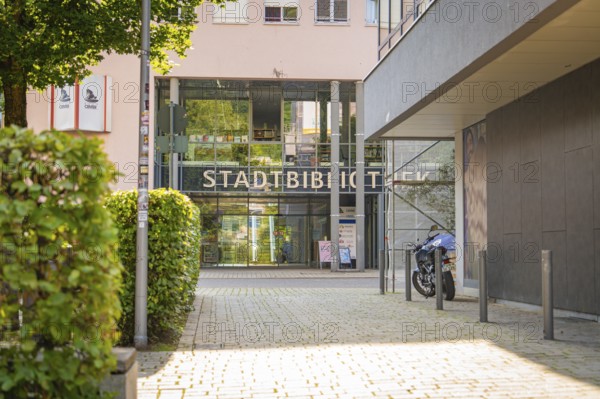 Modern entrance to a municipal library with glass façade and a motorbike in front, Nagold, district of Calw, Black Forest, Germany