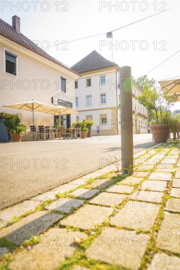 Cosy street scene with a café and seating, surrounded by sun-drenched buildings, Nagold, district of Calw, Black Forest, Germany