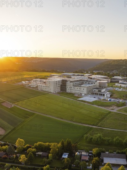Large building in a rural setting at sunset, surrounded by fields, small town of Perle Calw, Black Forest, Germany