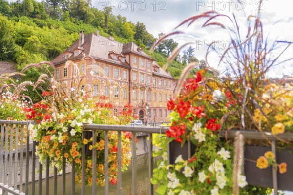 Historic building surrounded by summer flowers, taken over a bridge, small town of Perle Calw, Black Forest, Germany