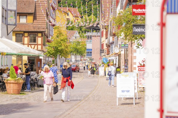 Lively street in an old town with passers-by and hustle and bustle on a sunny day, small town pearl Calw, Black Forest, Germany