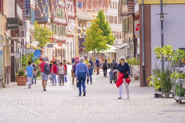 Lively pedestrian zone with people in a town with traditional half-timbered buildings and shops, small town pearl Calw, Black Forest, Germany