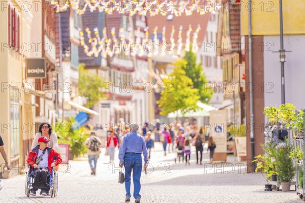 Lively shopping street with people in a sunny town with historic buildings, small town pearl Calw, Black Forest, Germany