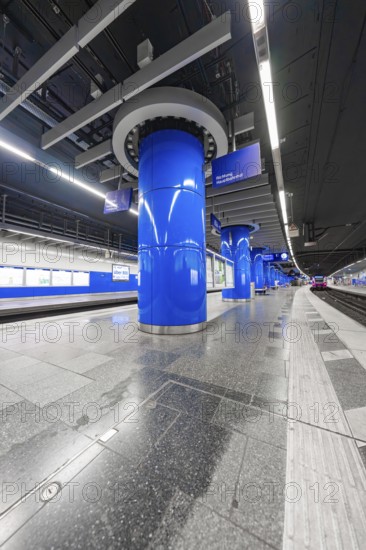 Modern underground station with blue columns and urban flair, Munich, Germany