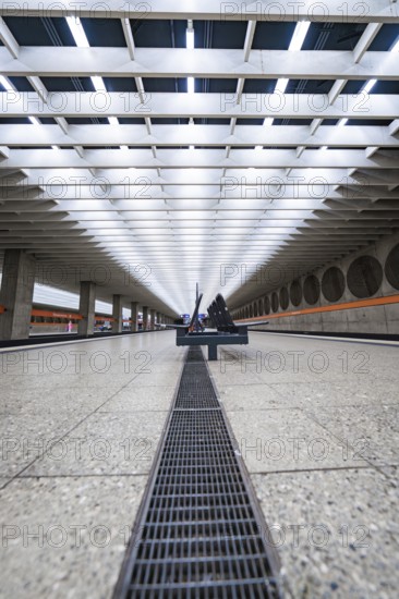 Symmetrical station concourse with modern benches and bright lighting, Munich, Germany