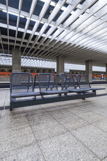 Modern railway station with benches and characteristic glass roof, Munich, Germany