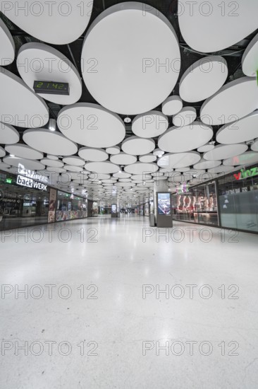 Light-flooded mall with modern round ceiling panels, Munich, Germany