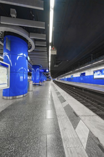 Modern underground station with blue design, empty platforms and smooth surfaces, Munich, Germany