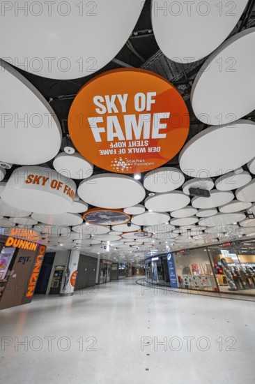 Modern shopping centre with eye-catching ceiling structure and various shops, Munich, Germany