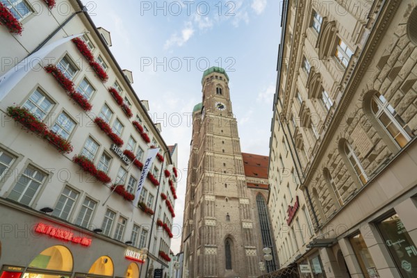 Historically significant church tower surrounded by old buildings under a clear sky, Munich, Germany