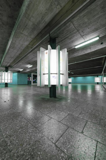 An empty, underground space with concrete walls and glowing green light creates a modern, urban atmosphere, Munich, Germany